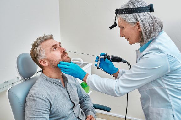 Un professionnel réalise une désinfection de haut niveau par essuyage d'un nasofibroscope à l'aide du système Tristel Trio Wipes System.
